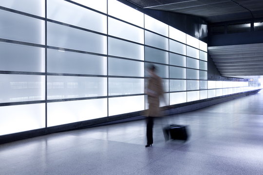 Person walking with motion blur in passageway at modern train station, Berlin, Germany