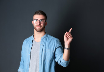 Fototapeta premium Portrait of a smiling young man pointing up