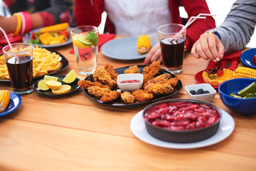 Group of people having dinner together while sitting at wooden table