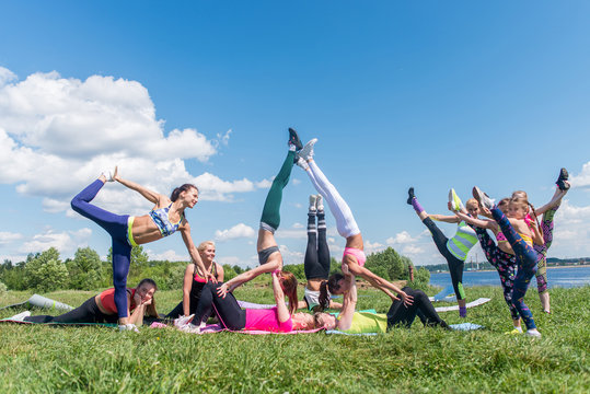 Group of fit women doing acrobatics trick outdoors