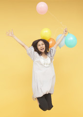 Fototapeta premium Young woman holding balloons