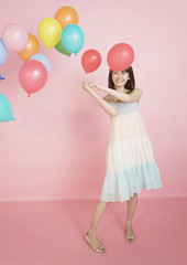 Young woman holding balloons