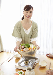 Young woman holding Japanese hot pot