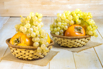 grapes, kaki and tangerine in wicker baskets
