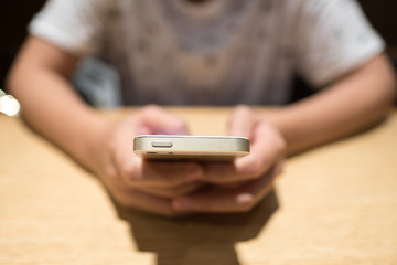 Woman using mobile phone on dinner table. Smart phone addict