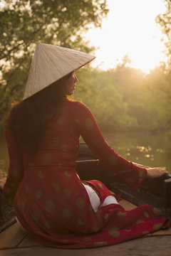 Woman wearing ao dai dress in boat, Can Tho, Mekong Delta, Vietnam