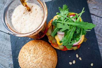 Homemade beef burger and soda on a black slate background, top view