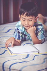 Asian boy reading a book. Education concept. Vintage tone effect