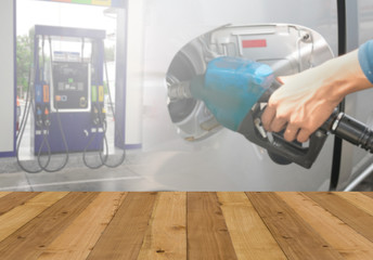 Wood floor and Hand holding Fuel nozzle pouring background