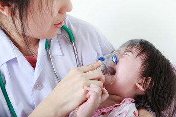 Asian girl having respiratory illness helped by doctor.
