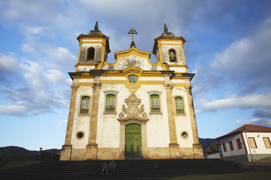 People sitting outside Sao Francisco of Assis Church in Praca Minas Gerais, Mariana, Minas Gerais, Brazil 