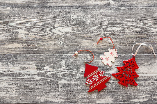 Background with red Christmas decorations trees on gray wooden b