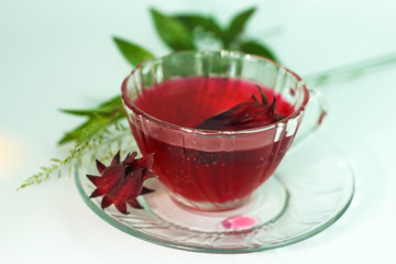 Glass of cold roselle juice - healthy food against wood