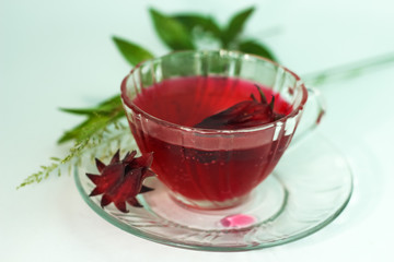 Glass of cold roselle juice - healthy food against wood