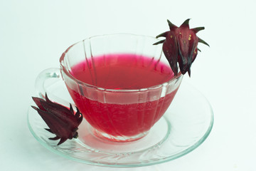 Glass of cold roselle juice - healthy food against wood