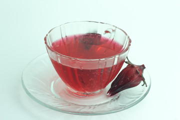 Glass of cold roselle juice - healthy food against wood