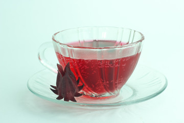 Glass of cold roselle juice - healthy food against wood