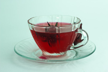 Glass of cold roselle juice - healthy food against wood