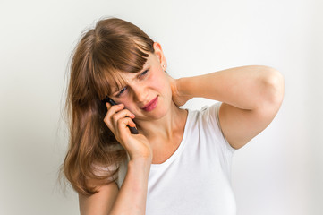 Woman with mobile phone having pain in her neck