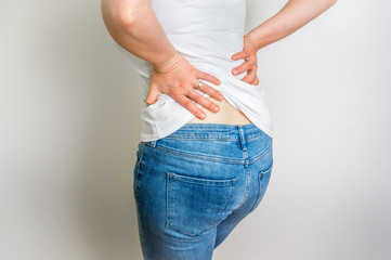 Woman with back pain holding her aching back