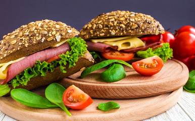 Burger sandwich with ham, cheese, tomatoes and lettuce