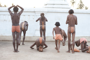 Joranda monks performing obeisance at temple containing a dhuni, an eternal butter lamp, at dusk, Joranda, Dhenkanal, Orissa
