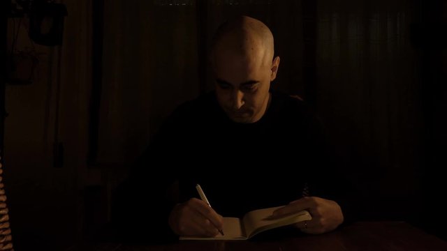 bald theater director takes notes on his diary after a rehearsal