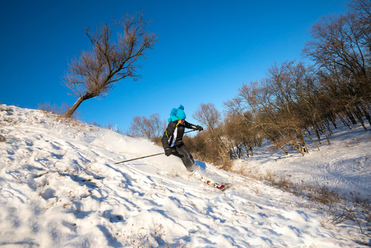 Woman skiing downhill on background of blue sky