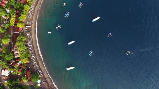 Aerial shoot of a calm lagoon with boats and buildings. Bali, Indonesia