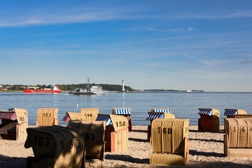 Strandkörbe an der Kieler Förde mit Schiffsverkehr