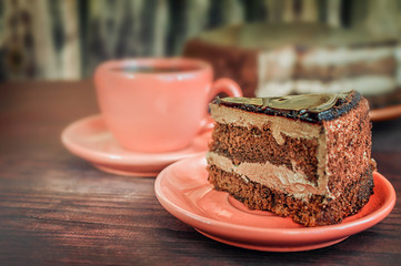Tasty chocolate cake on a red plate on a wooden table background