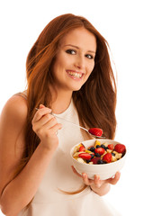 healthy eating  - woman eats a bowl of fruit salad isolated over