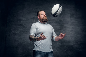 The bearded rugby player catching a game ball.