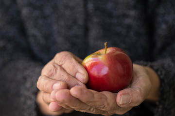 senior woman holding apple