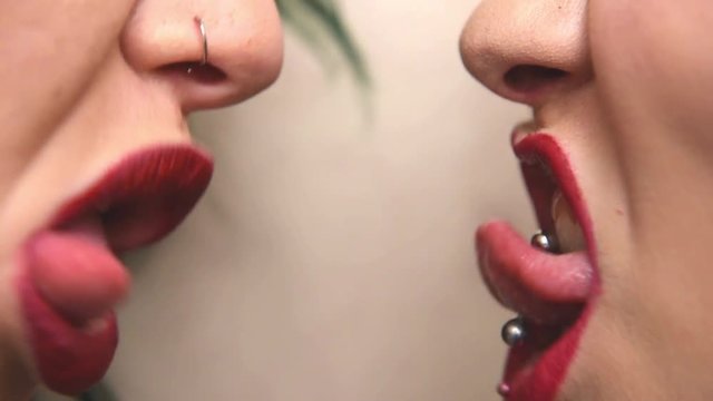 Women couple red lips one close in front of other grimace detail close up