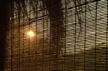 sun spreading light through bamboo curtain in Thai traditional home