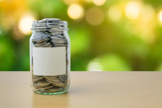 Money bottle with coins on bokeh background