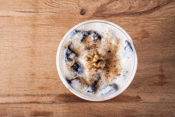 Desserts with prune, walnut and sour cream in vase. 