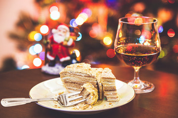 Christmas dessert. Cake on plate and glass of cognac in