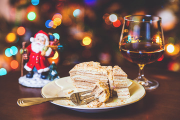 Christmas dessert. Cake on plate and glass of cognac in