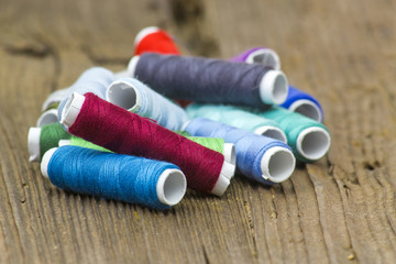 spools of thread on a wooden background