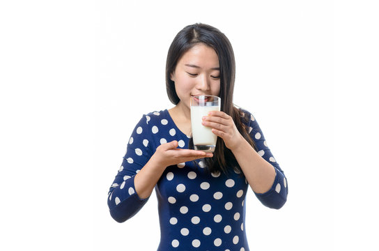Young Chinese woman drinking a glass of milk