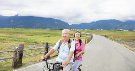 happy Senior  Couple Riding Bicycle on country road
