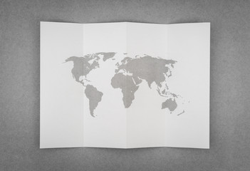 Paper folded with world map .