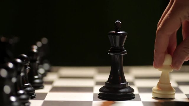 Panoramic shot of a chess board, with white pawn conquering the black king.