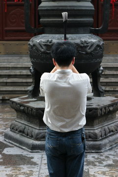 Prayer with incense in the Shanghai White Jade Buddha temple, Shanghai, China