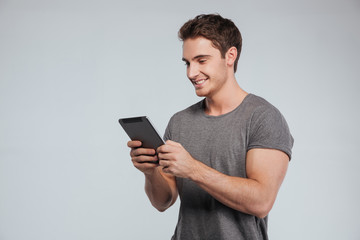 Portrait of a happy casual man using tablet computer