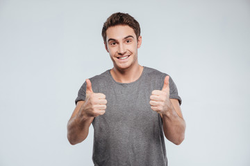 Portrait of a happy smiling man showing two thumbs up