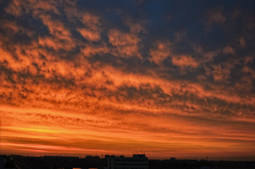 Dramatic sunset and sunrise sky over residential building roofs