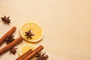 Fototapeta na wymiar seasoning cinnamon (Cinnamomum), anise (Anisium vulgare Gaerto) and lemon lies on a light wood surface, spilled from a jar, close-up, background, healthy lifestyle